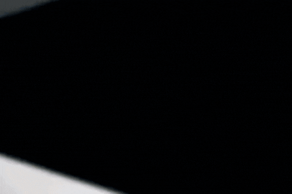 Extreme close-up of a dark, freshly tinted car window with smooth, flawless finish, showcasing the precision of a professional tint job.